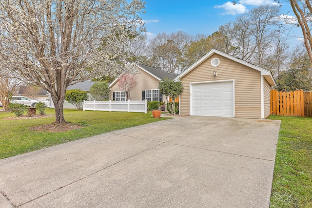 ranch-style home with concrete driveway, a detached garage, a front yard, and fence