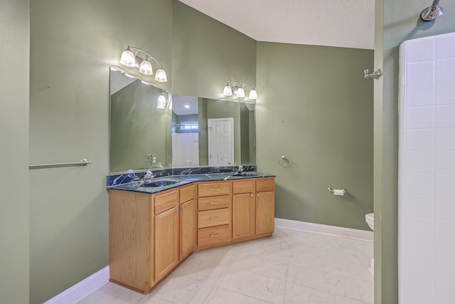 full bathroom with double vanity, baseboards, and a sink