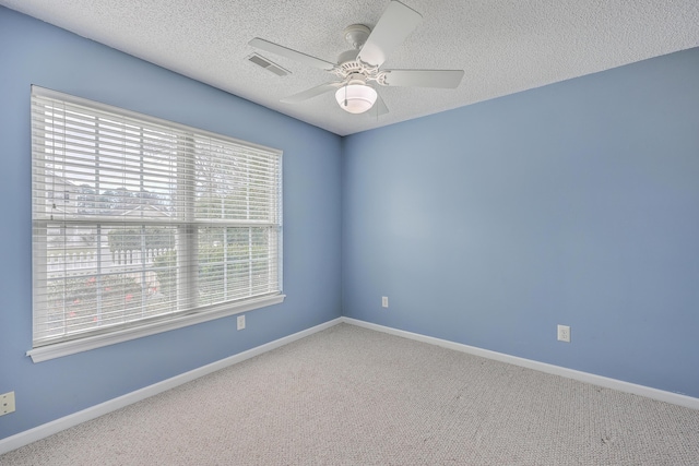 unfurnished room with visible vents, baseboards, ceiling fan, carpet flooring, and a textured ceiling