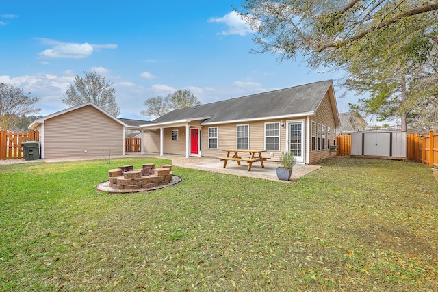 view of front facade with an outdoor fire pit, a storage shed, a fenced backyard, an outbuilding, and a patio