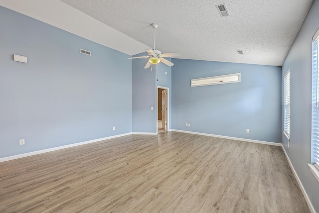 unfurnished room featuring vaulted ceiling, wood finished floors, visible vents, and ceiling fan