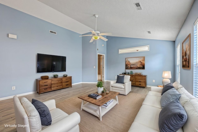 living room featuring visible vents, light wood-type flooring, and a ceiling fan