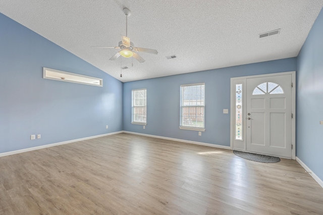 foyer entrance with visible vents, baseboards, ceiling fan, wood finished floors, and a textured ceiling