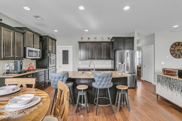 219 Daybreak Blvd, Summerville, SC 29486 - kitchen with visible vents, a kitchen island with sink, a sink, light wood-style floors, and appliances with stainless steel finishes