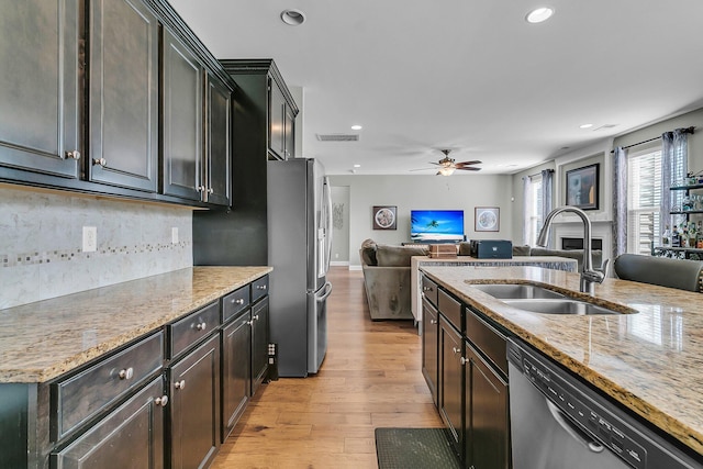 219 Daybreak Blvd, Summerville, SC 29486 - kitchen featuring light wood-type flooring, a sink, backsplash, open floor plan, and stainless steel appliances