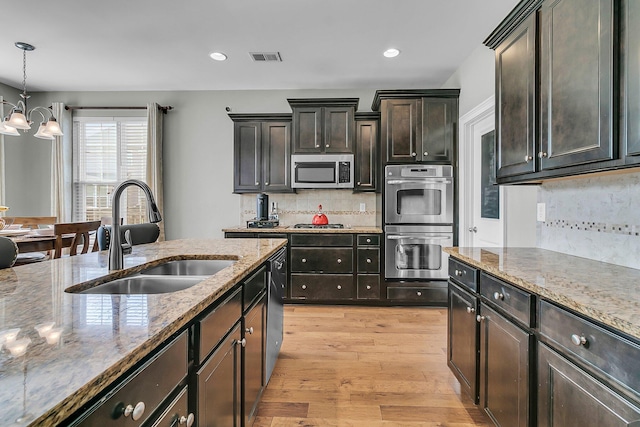 219 Daybreak Blvd, Summerville, SC 29486 - kitchen with visible vents, a sink, light stone counters, light wood-style floors, and appliances with stainless steel finishes