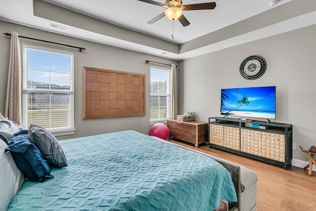 219 Daybreak Blvd, Summerville, SC 29486 - bedroom with visible vents, a ceiling fan, a tray ceiling, wood finished floors, and baseboards