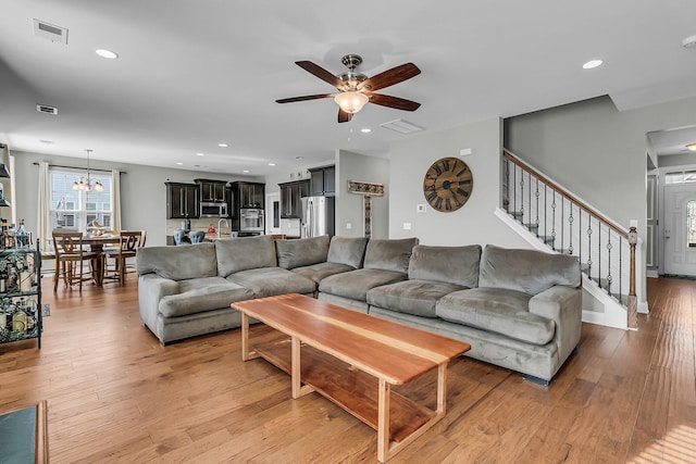 219 Daybreak Blvd, Summerville, SC 29486 - living room featuring visible vents, ceiling fan with notable chandelier, recessed lighting, stairway, and light wood finished floors