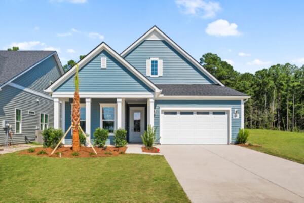 view of front facade featuring a porch, driveway, a front yard, and a garage