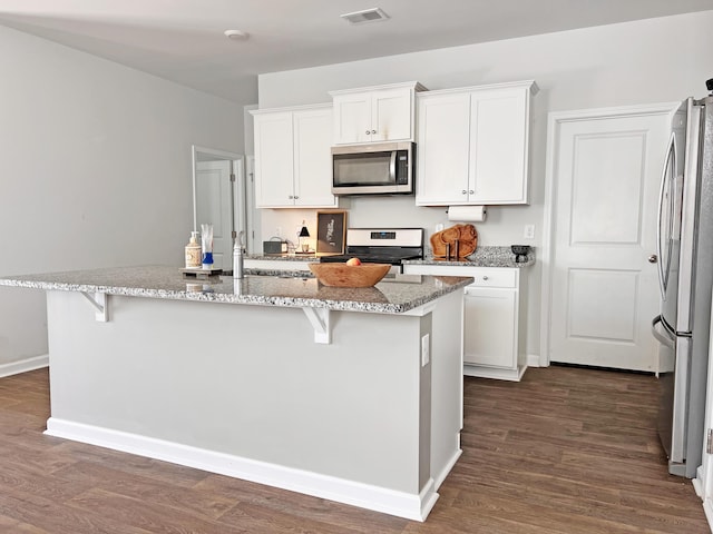 323 Bear Paw Ln, Summerville, SC 29486 - kitchen with appliances with stainless steel finishes, white cabinetry, a kitchen island with sink, light stone countertops, and a kitchen breakfast bar