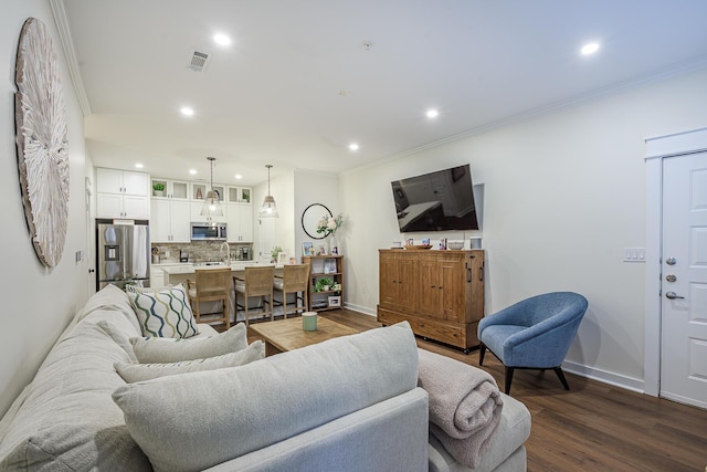 living room featuring dark wood-type flooring and ornamental molding