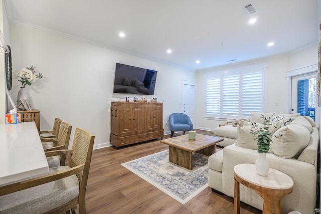 living room with light wood-type flooring and ornamental molding