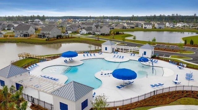 view of swimming pool featuring a water slide, a patio area, and a water view