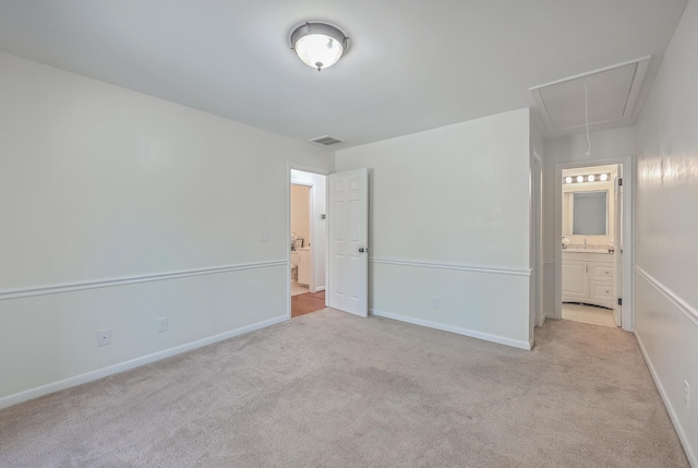 unfurnished bedroom featuring connected bathroom and light colored carpet