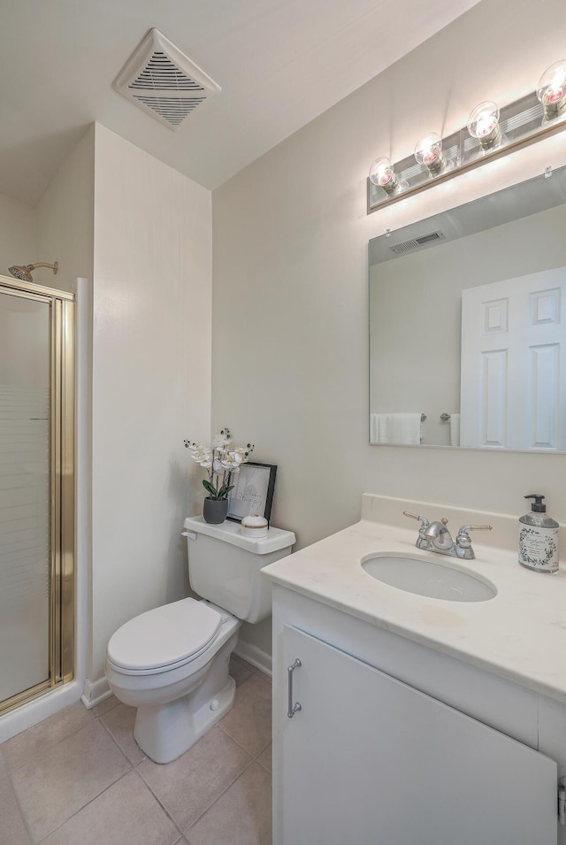 bathroom with vanity, a shower with shower door, tile patterned floors, and toilet