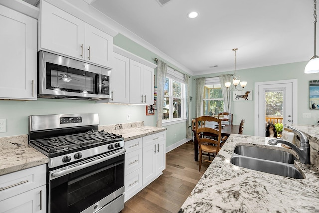 kitchen featuring white cabinets, sink, hanging light fixtures, a wealth of natural light, and stainless steel appliances