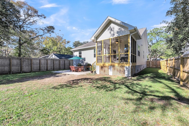 rear view of house with a lawn, a sunroom, and a patio