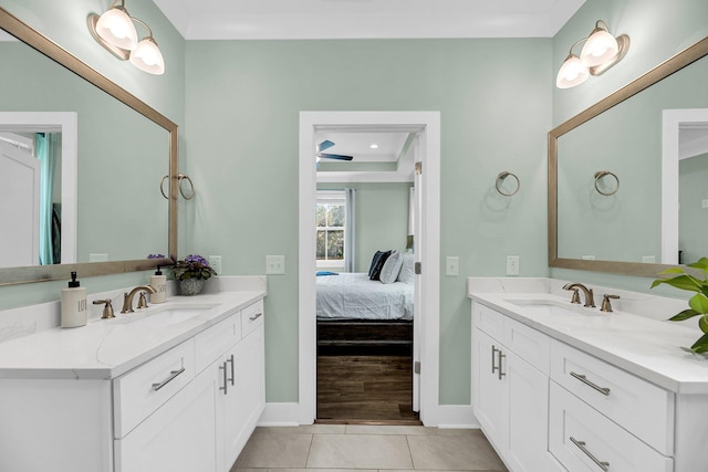 bathroom with vanity, a tray ceiling, tile patterned floors, and crown molding