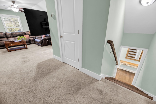 staircase featuring carpet, ceiling fan, and lofted ceiling