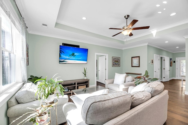 living room with a tray ceiling, ceiling fan, hardwood / wood-style floors, and ornamental molding