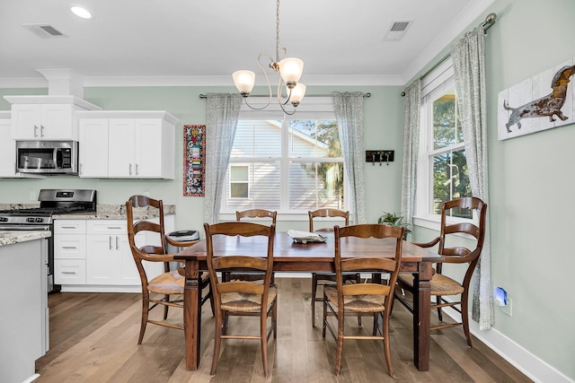 dining area featuring crown molding, dark hardwood / wood-style flooring, and a notable chandelier