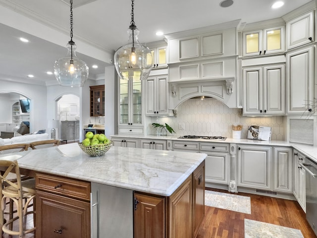 kitchen with refrigerator, white gas cooktop, decorative light fixtures, a center island, and white cabinetry