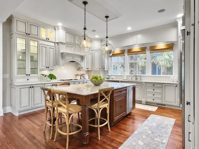 kitchen featuring a kitchen breakfast bar, decorative backsplash, a kitchen island, and dark wood-type flooring