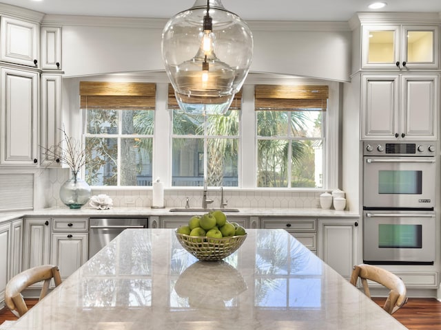 kitchen with light stone counters, white cabinetry, sink, and appliances with stainless steel finishes