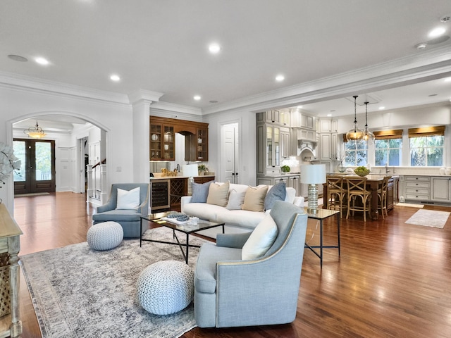 living room featuring french doors, beverage cooler, crown molding, sink, and dark hardwood / wood-style floors