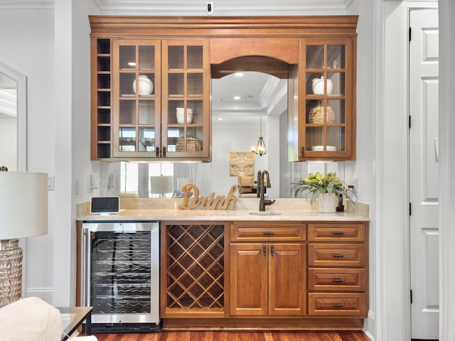 bar featuring wine cooler, sink, wood-type flooring, and ornamental molding