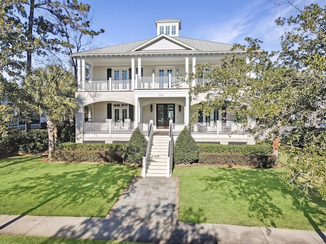 view of front of house featuring a porch, a balcony, a front yard, and french doors