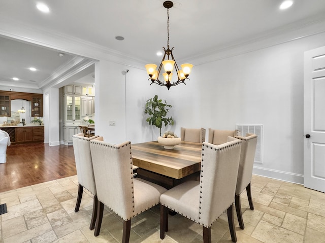 dining area with a chandelier and ornamental molding