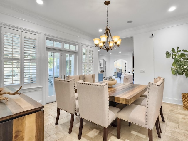 dining room with a notable chandelier, crown molding, and french doors