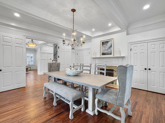 dining area featuring beamed ceiling, dark hardwood / wood-style flooring, ornamental molding, and an inviting chandelier