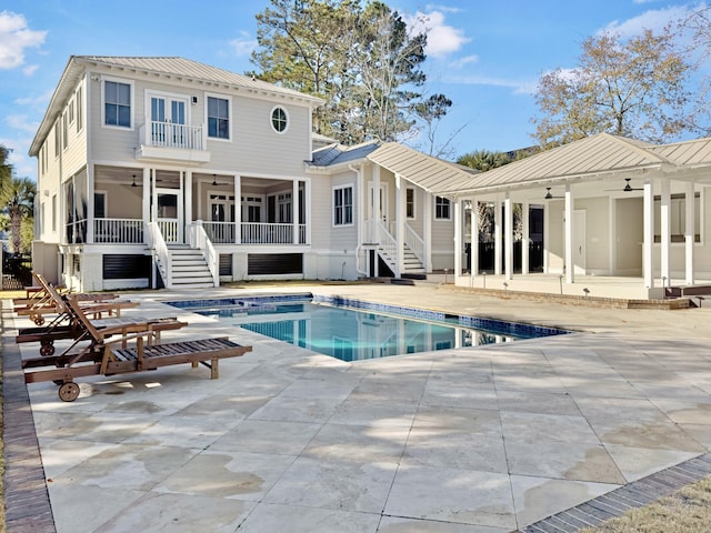 rear view of house with ceiling fan, a patio area, and a balcony