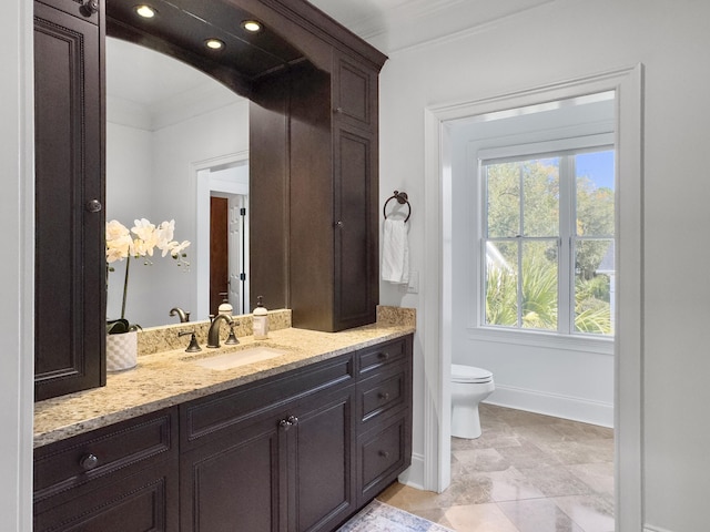 bathroom featuring vanity, toilet, and ornamental molding