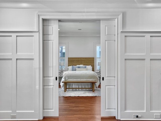 bedroom featuring wood-type flooring and crown molding