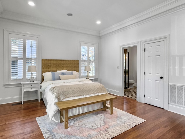 bedroom with connected bathroom, crown molding, and dark wood-type flooring