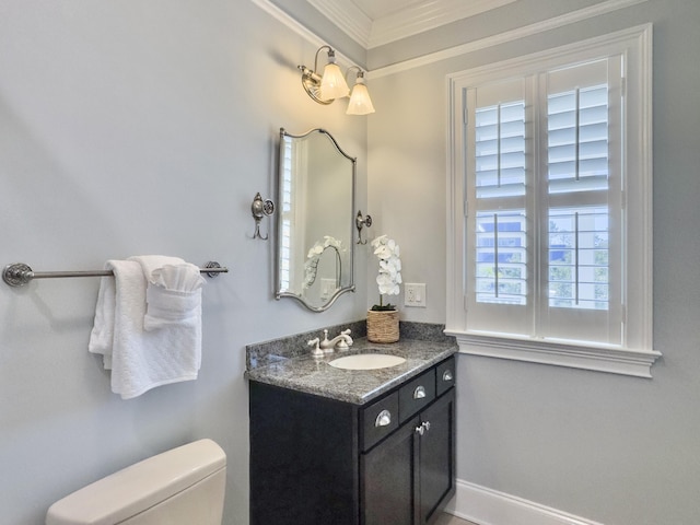 bathroom featuring vanity, toilet, a wealth of natural light, and ornamental molding