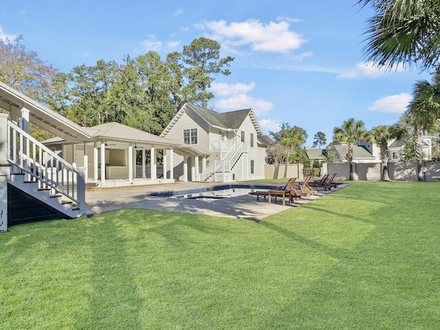 back of house featuring a fenced in pool, a patio area, and a lawn