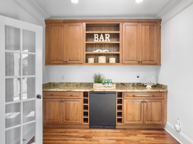 bar featuring refrigerator, light stone countertops, ornamental molding, and light wood-type flooring