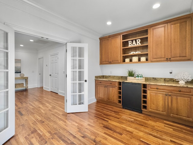 bar with light stone countertops, french doors, crown molding, fridge, and hardwood / wood-style flooring