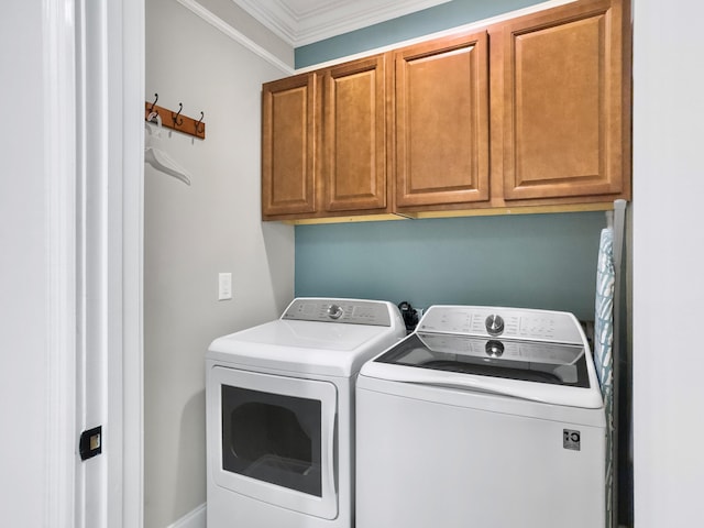 washroom with washer and dryer, cabinets, and ornamental molding