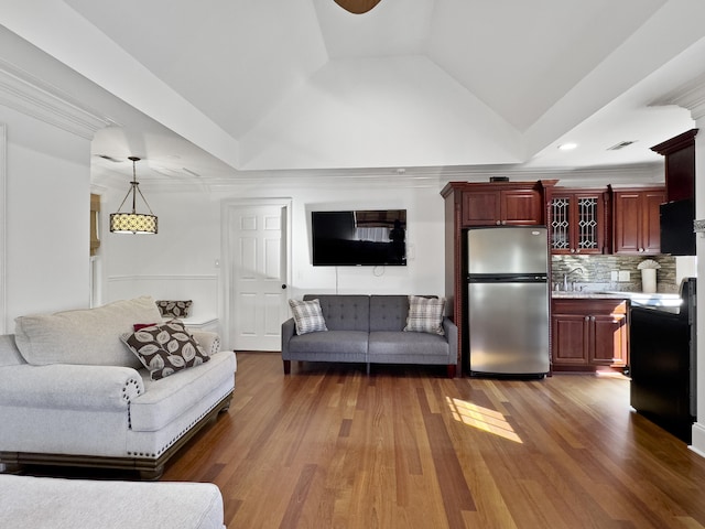 living room featuring crown molding, sink, dark hardwood / wood-style floors, and vaulted ceiling