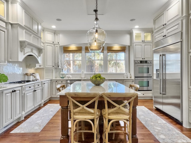 kitchen featuring white cabinetry, stainless steel appliances, backsplash, crown molding, and decorative light fixtures