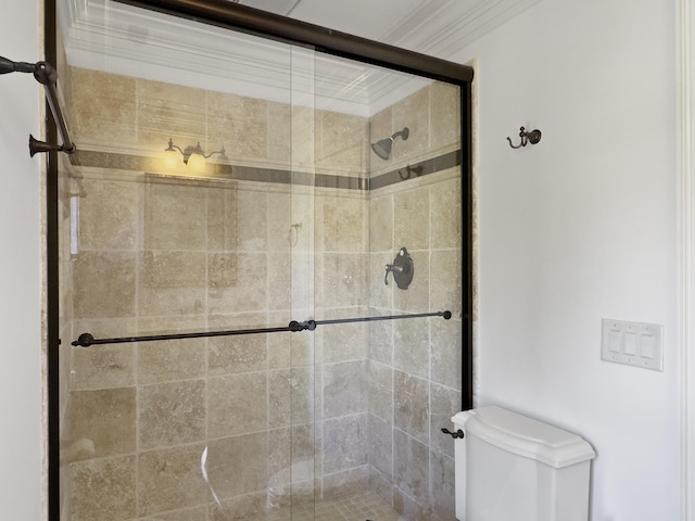 bathroom featuring toilet, an enclosed shower, and ornamental molding