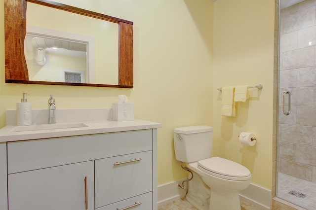 bathroom featuring a shower with door, vanity, and toilet