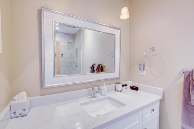 bathroom featuring a tile shower and vanity