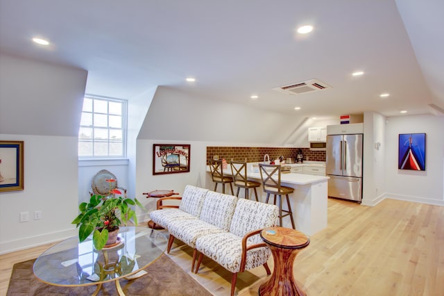 living room featuring light wood-type flooring and lofted ceiling