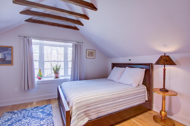 bedroom featuring lofted ceiling with beams and light hardwood / wood-style flooring